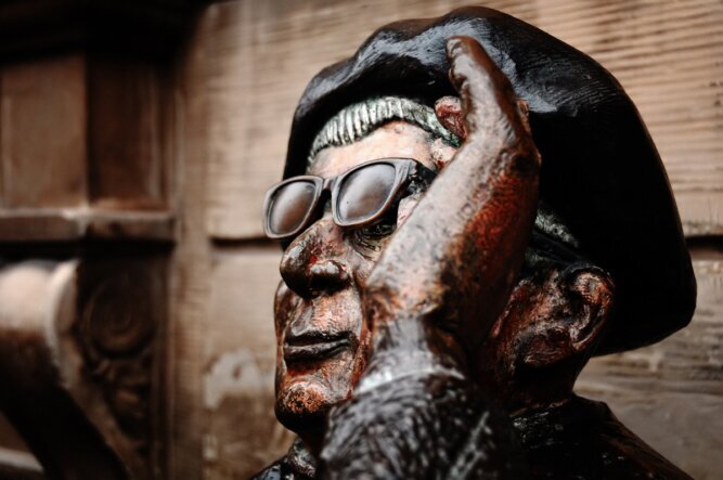 Bedeutung entsteht im Auge des Betrachters Das Photo zeigt den Ausschnitt einer Statue in Stockholm. Es zeigt einen Mann mit Hut, der seine Sonnenbrille anhebt, um darunter durchzuschauen.<br />©memephoto