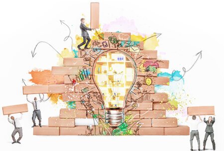 Vier Menschen bauen eine Mauer mit einem Graffiti einer Glühlampe.<br />©alphaspirit, ©memephoto