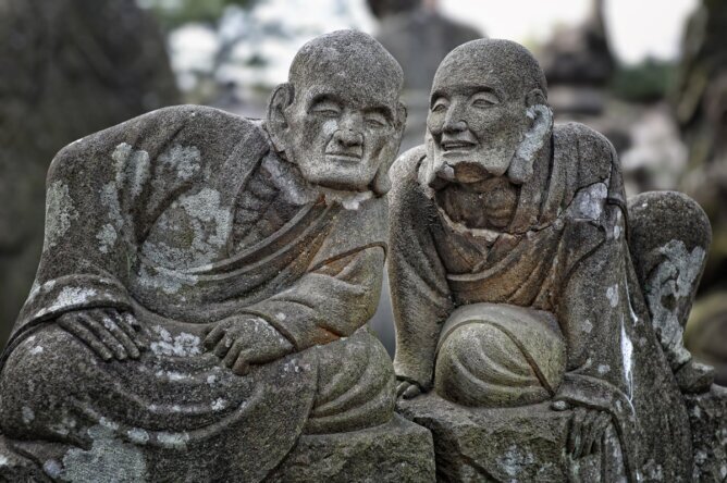 Das Photo zeigt zwei japanische Statuen, die miteinander tuscheln.<br />©memephoto
